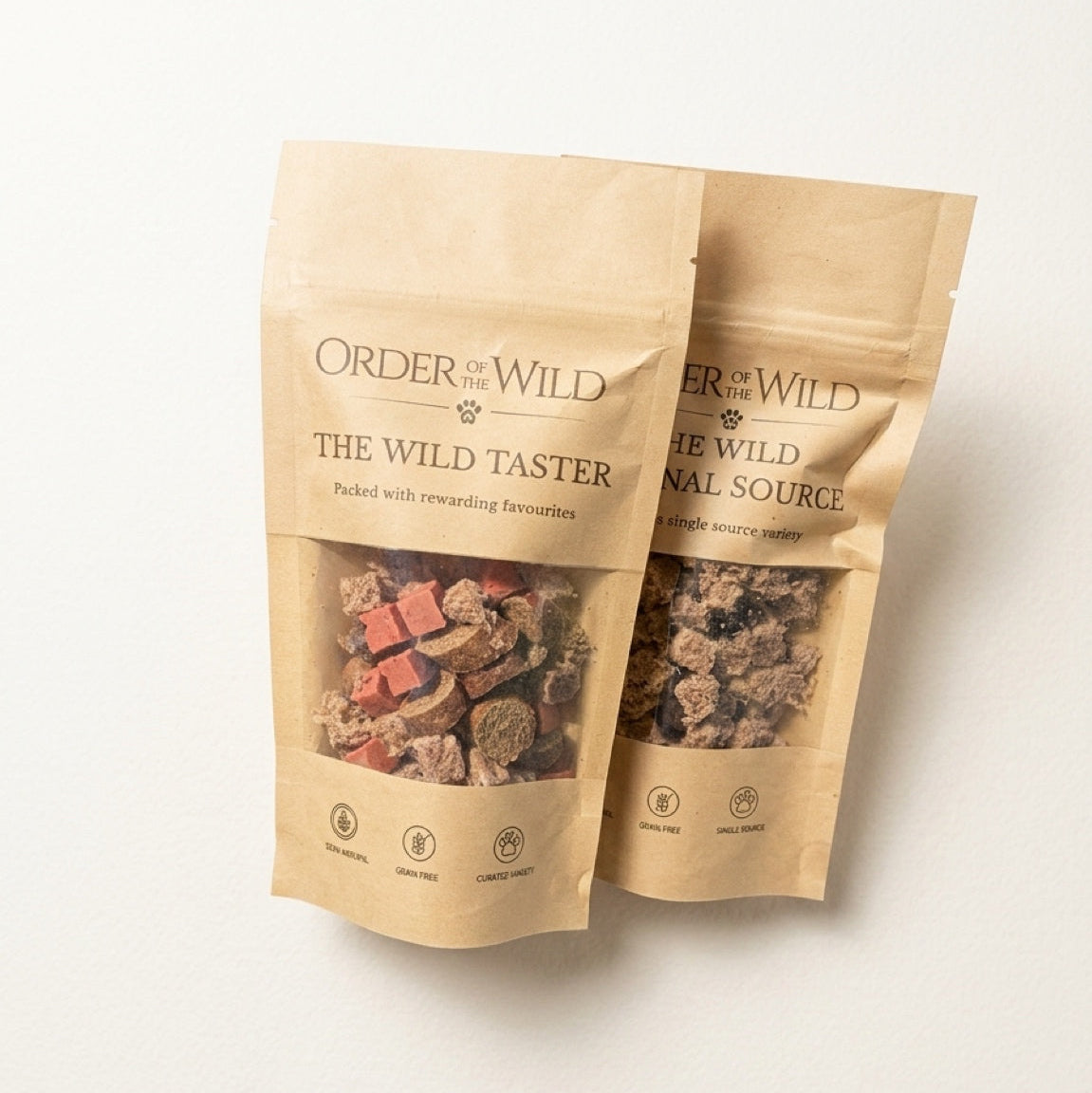 Two packages of 'Order of the Wild' pet treats on a white background