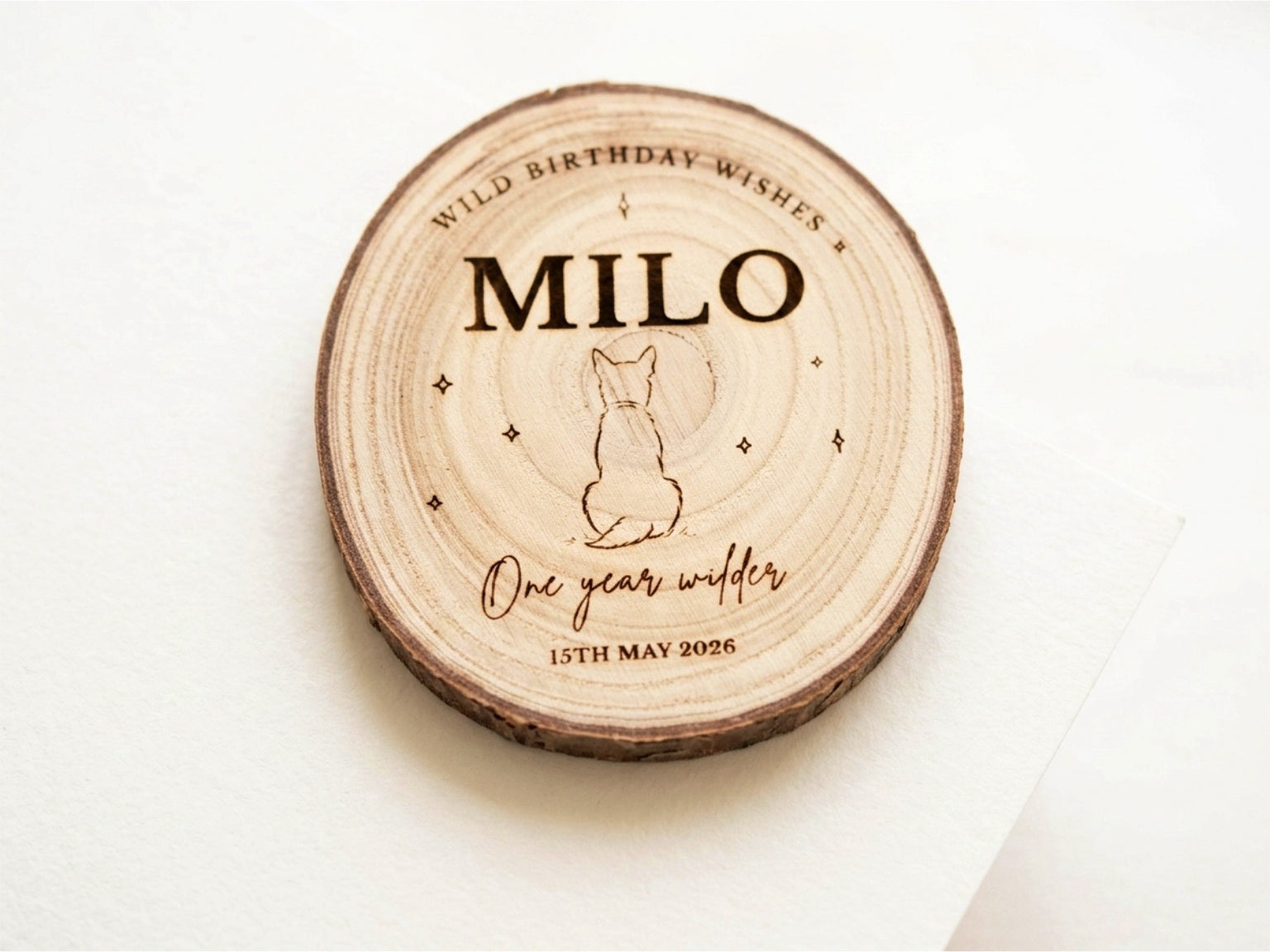 Wooden circular plaque with engraved text and a dog illustration on a white background